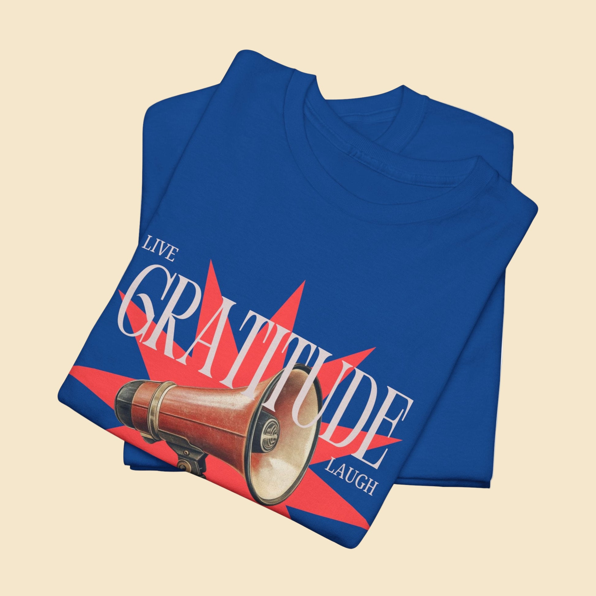 Folded blue t-shirt with a graphic design featuring a megaphone and text on a white background
