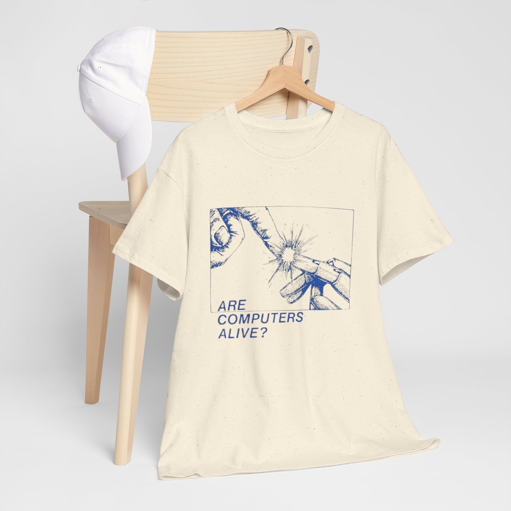 Beige t-shirt with graphic design and text on a wooden chair against a white background