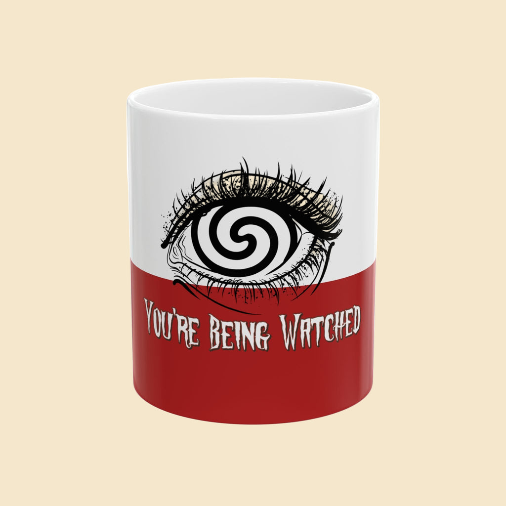 Mug with eye design and text 'You're Being Watched' on a white background