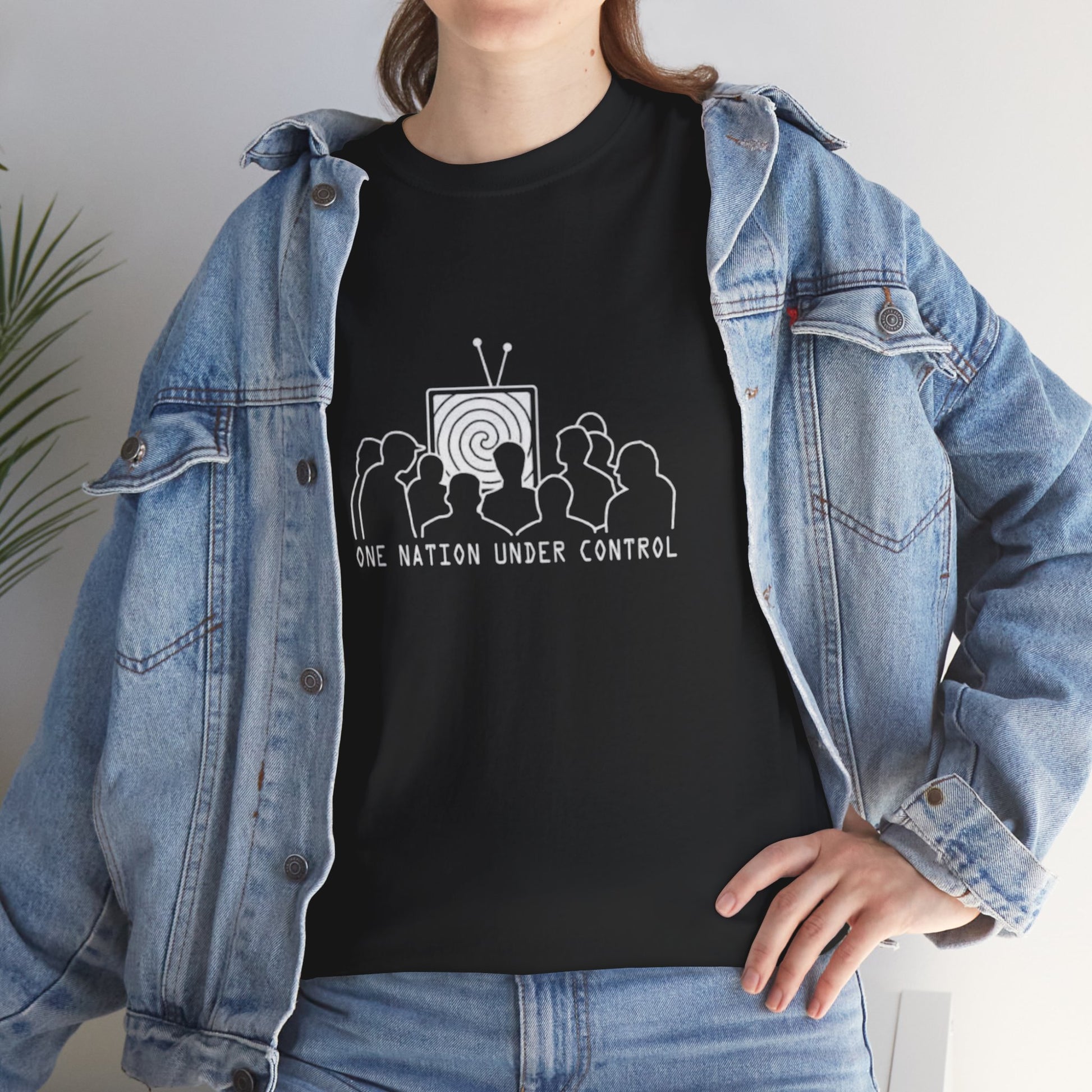 Person wearing a black t-shirt with a graphic design and text, paired with a denim jacket.