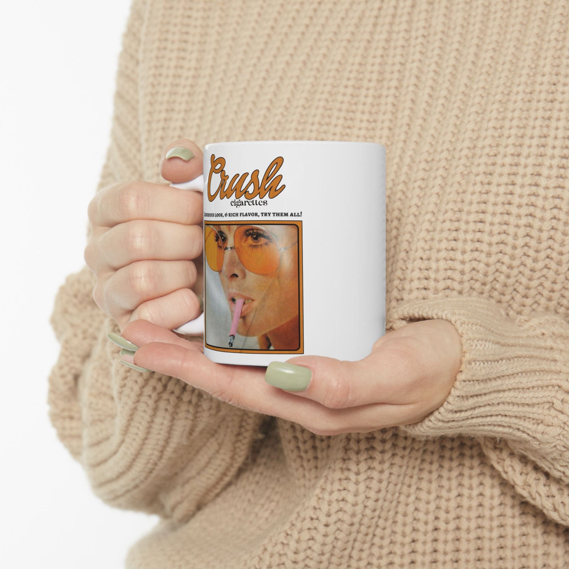 Person holding a mug with a graphic design on a beige background