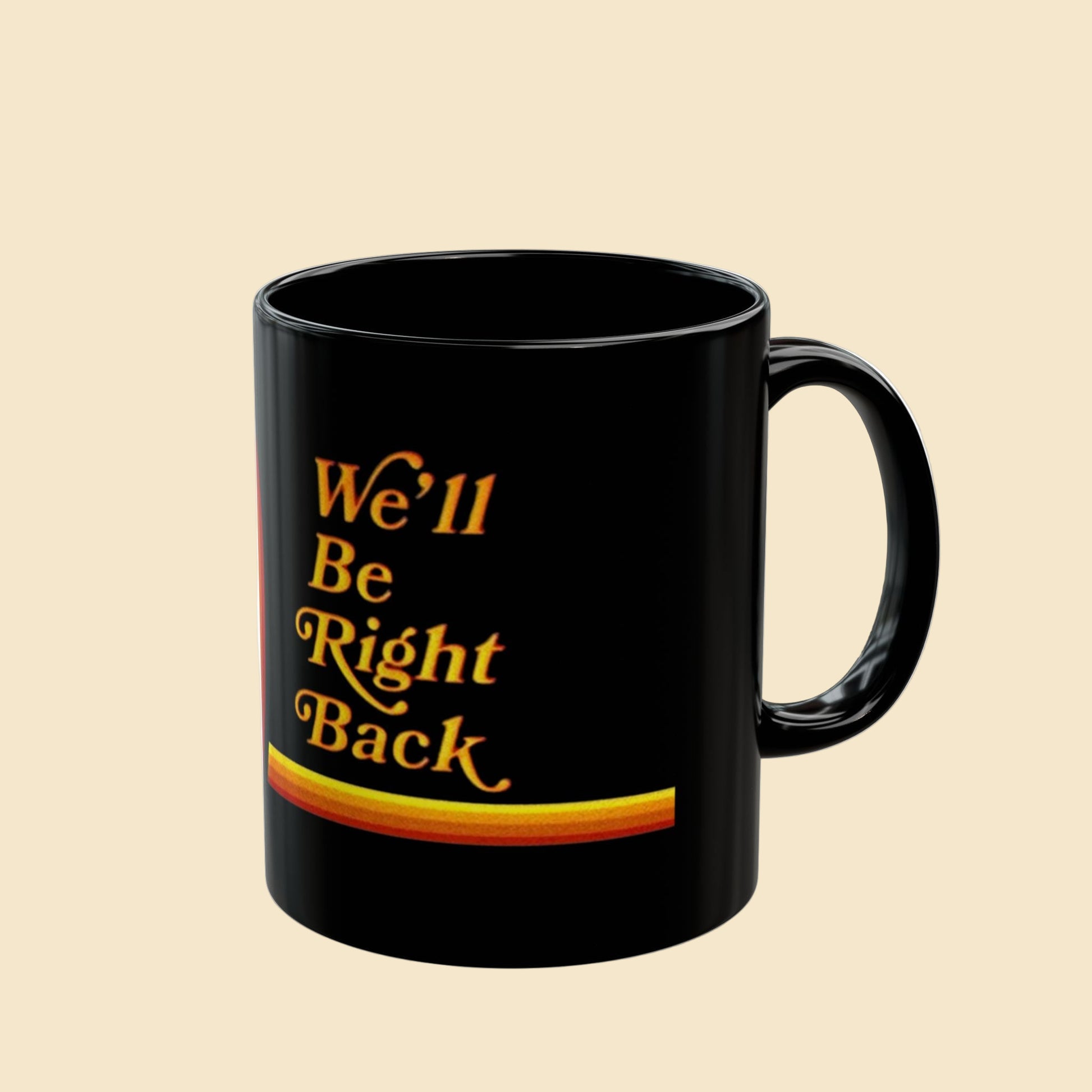Black mug with 'We'll Be Right Back' text in yellow on a white background