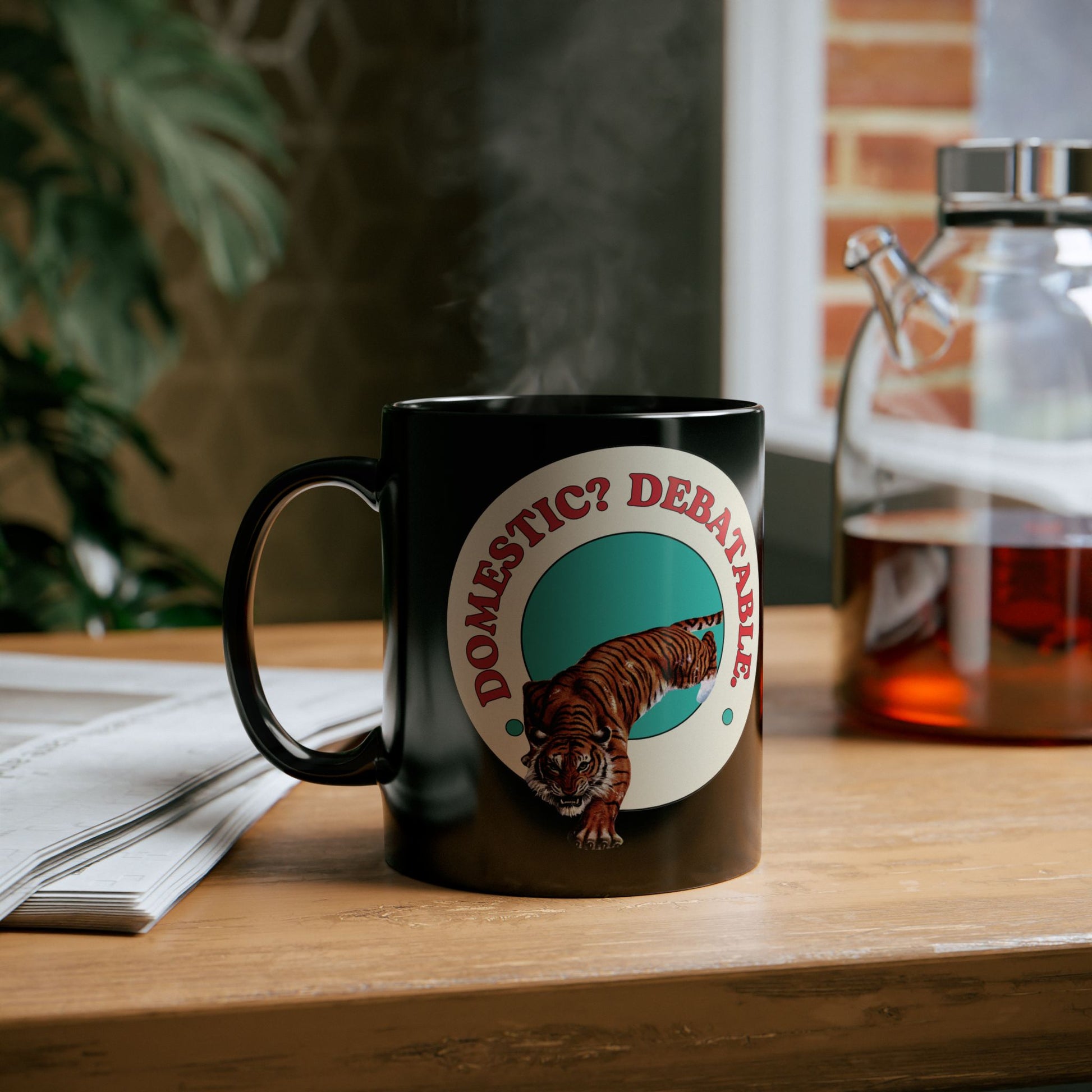 Black mug with a tiger graphic and text on a wooden surface